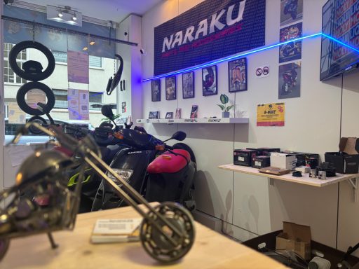 Ein Motorradmodell im Vordergrund, im Hintergrund ein Verkaufsraum mit Zubehör und Werbung.