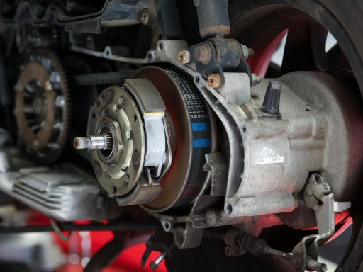 Nahaufnahme eines Motors mit sichtbarem Antriebssystem und rotierenden Teilen.
