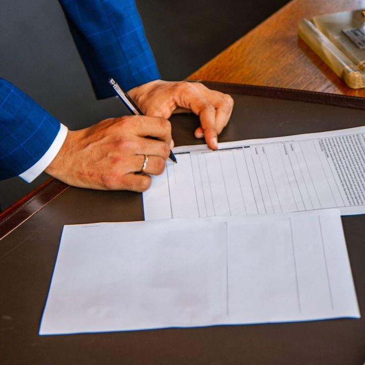 Hände eines Mannes dessen ein dokument unterschreiben